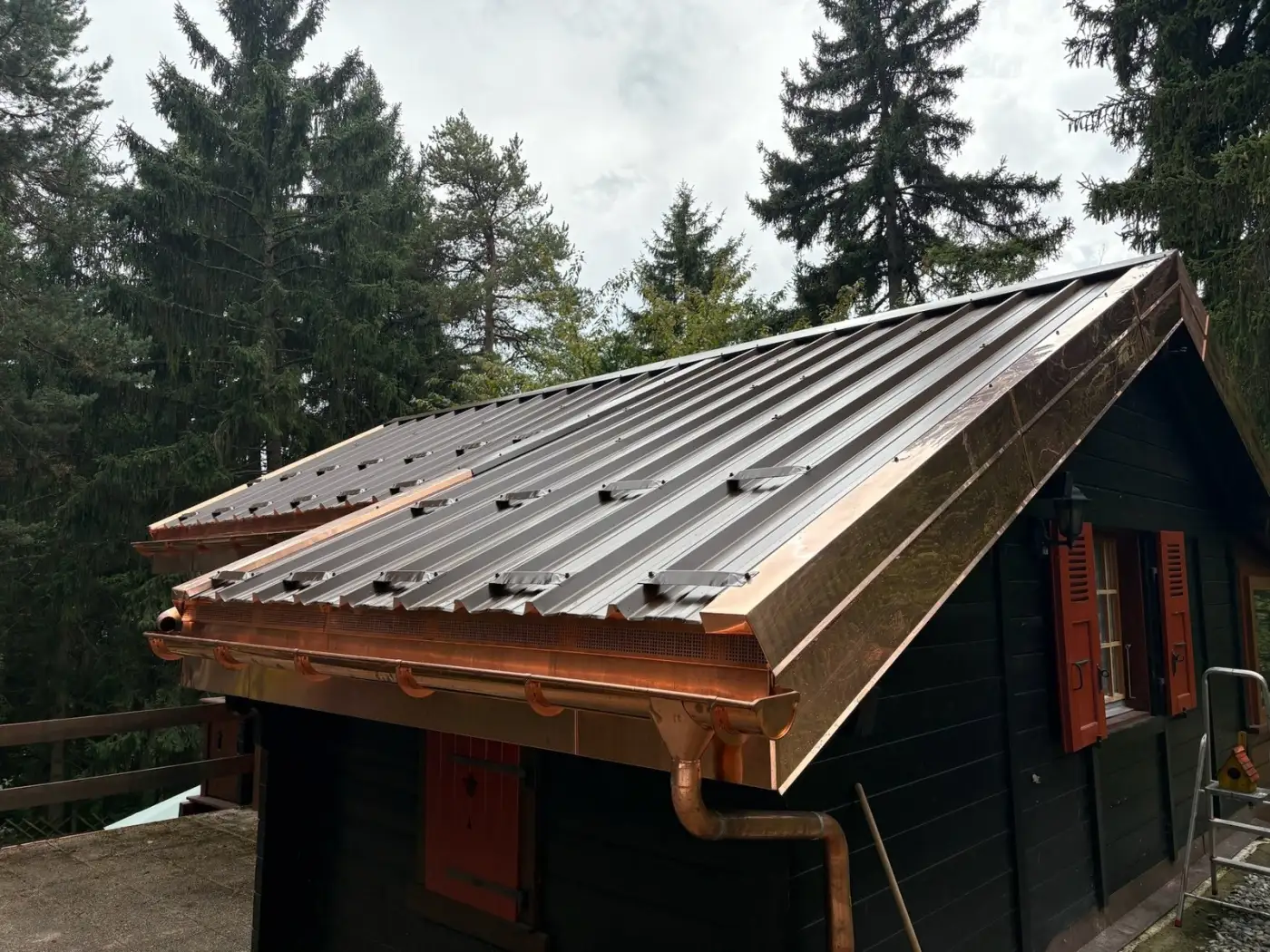 Rénovation complète de toiture avec isolation thermique, couverture en tôle trapézoïdale et ferblanterie en cuivre.
